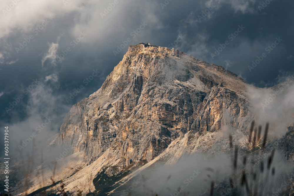 Monte Lagazuoi Piccolo. Dramatic mountain landscape with golden sun and dark clouds. View from Cinque Torri, Dolomites, Italy. Falzarego pass in Dolomiti Ampezzane, Veneto, Alps, Europe.