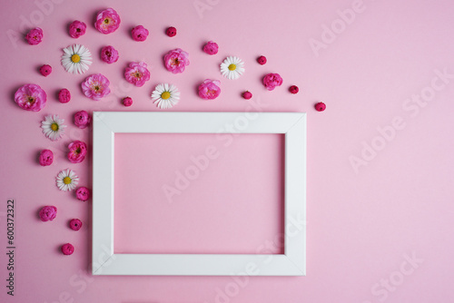 Flat lay, creative layout of blossoms, buds and petals of cherry, plum and daisy flowers with frame on a pink background. Prunus Triloba Louiseania. Mockup for greeting card. Copy space © GT77