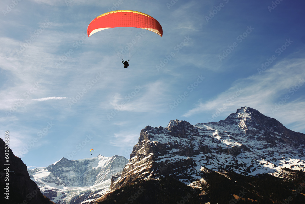 Paraglider in the mountains with clouds in the sky in Swiss Alps Paraglider in the mountains with clouds in the sky in Swiss Alps