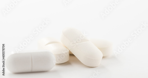 Close-up view of white pills or tablets on white background.