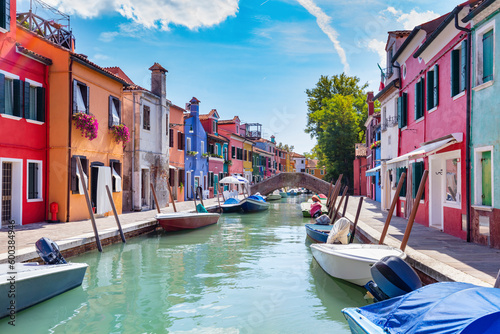 Burano, Italy with colorful painted houses along canal with boats