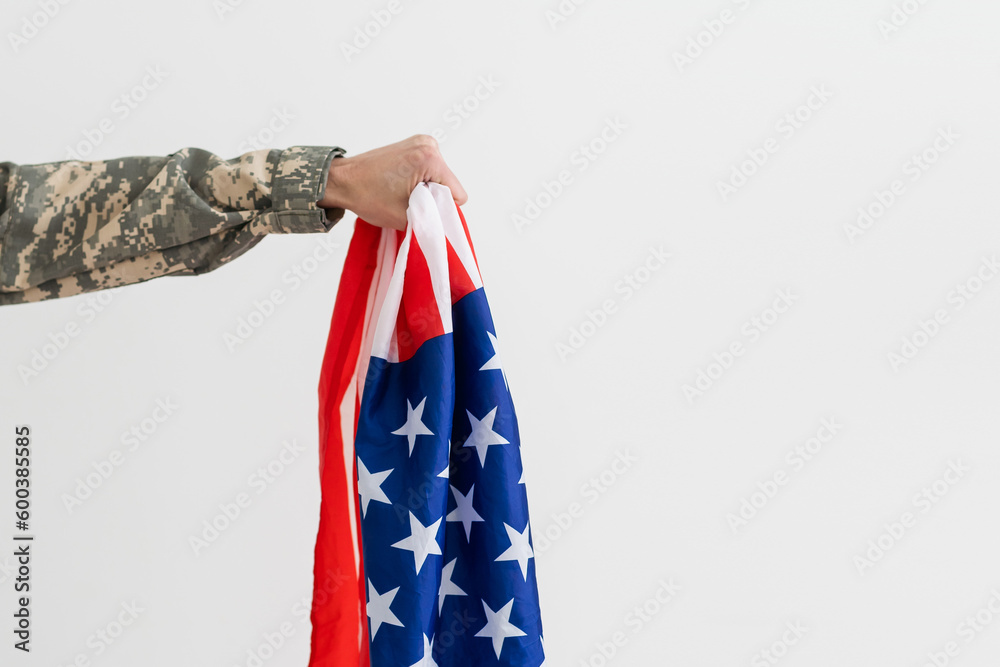 american military soldier holding flag. male officer in camouflage uniform. Concept of military, army.