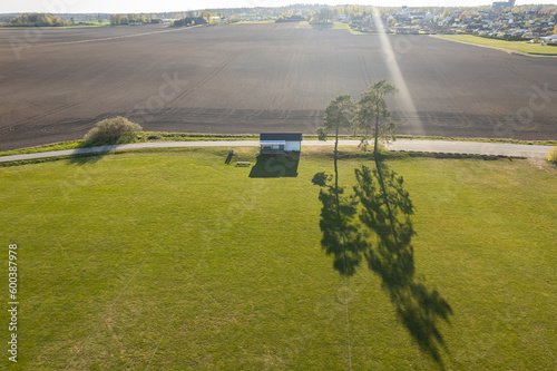 Aerial view of the fields  football pitch. Agriculture  sunny day. Amazing nature environment  ecology. Lonely house in the field  big and beautiful shadow. Ideal place for introverts. 