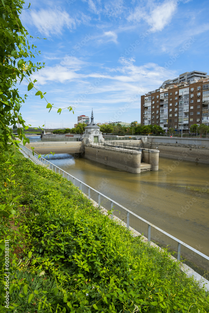Riverside landscape with many plants and buildings in the city of Madrid