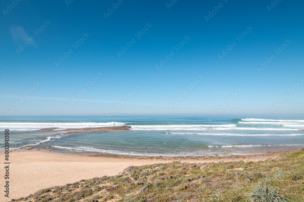 Huge beach Praia do Farol u města Vila Nova de Milfontes in the Odemira region, western Portugal. Wandering along the Fisherman Trail, Rota Vicentina