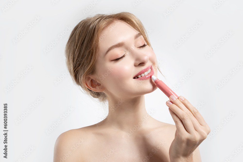 Portrait of gorgeous smiling woman holding rosy lipstick in hand. Beauty and cosmetics concept. Portrait of gorgeous smiling woman holding rosy lipstick in hand. Beauty and cosmetics concept.