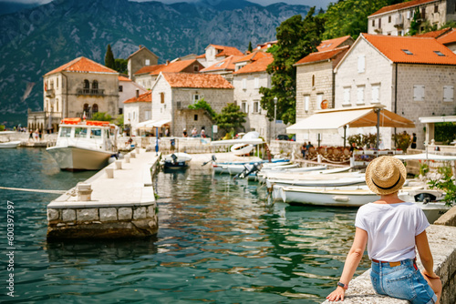 Rear view of a tourist woman looking at the small port of Perast © Anna Lurye