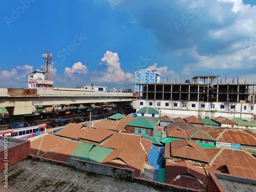 A view of a building under construction behind a roadside marketplace with a sky background.