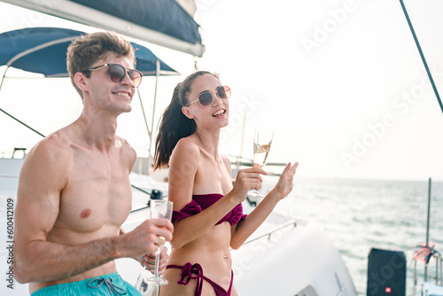 Happy couple person on yacht in ocean celebrate with champagne on vacation or holiday in summer, Young man with luxury wine, cruise at sea with woman for celebration or honeymoon travel trip on ship