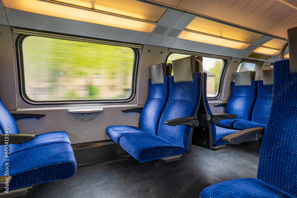 Passenger train with empty seats. Wide-angle long exposure, blurry green background out the window of an empty train in Switzerland, Europe, no people