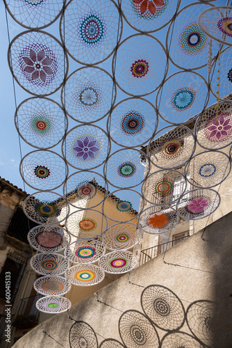 Crochet awning with drawings of mandalas in circles forming a triangle, manual work with aerial installation rural town of Huesca, Coscojuela de Fantova, Europe. Charming micro towns