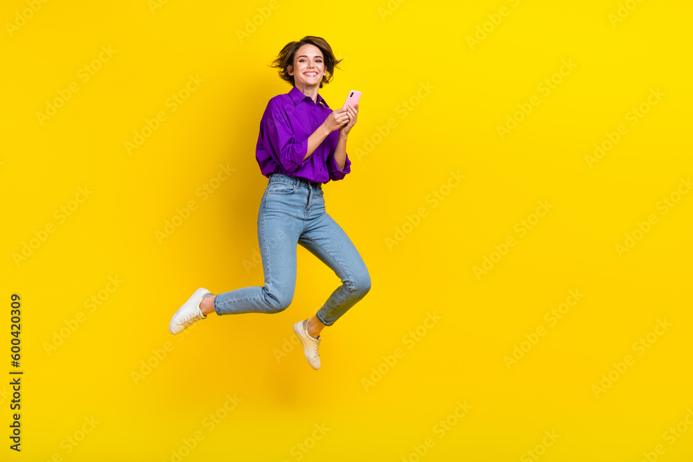 Full body size photo of careless girl hold phone wear purple shirt formal style use phone for zoom call isolated on yellow color background