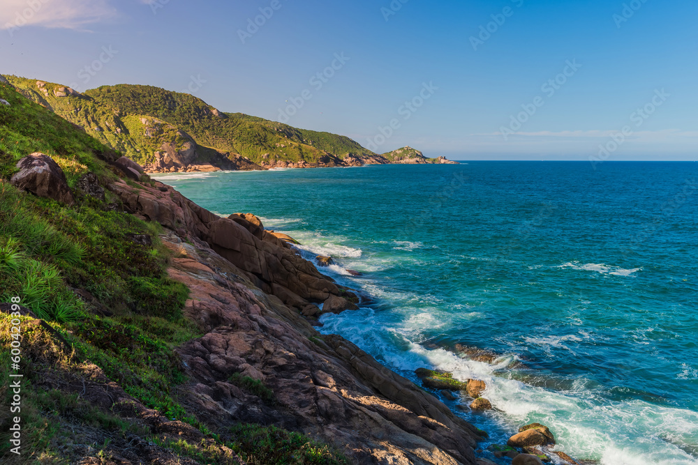 Fototapeta premium Scenic coastline and turquoise ocean with evening sunlight in Brazil.