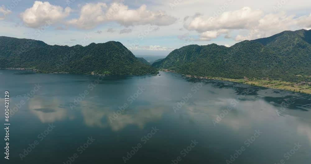 Aerial drone of lake Maninjau in mountains. Tropical landscape with mountains and a lake. Sumatra, Indonesia. Aerial drone of lake Maninjau in mountains. Tropical landscape with mountains and a lake. Sumatra, Indonesia.