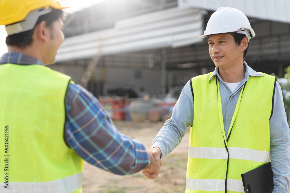 construction worker and contractor. Client shaking hands with team builder in the factory construction site. construction worker and contractor. Client shaking hands with team builder in the factory construction site.