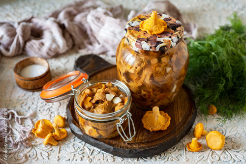 Preparation for winter: pickled chanterelles in a jar on a white background. A savory snack for lunch or dinner. Canned mushrooms. Close-up.
