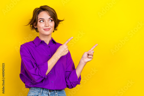 Photo of young consultant woman wear violet shirt direct fingers empty space tips for your business isolated on yellow color background