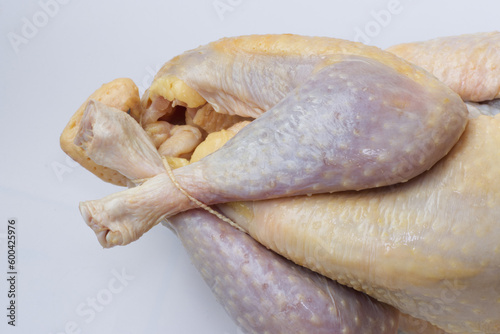 Close up on raw farm guinea fowl ready to cook on white background.