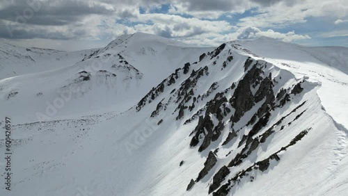 A cinematic drone footage captures snowy peaks of Shpyci and Rebra, Carpathian mountains. photo