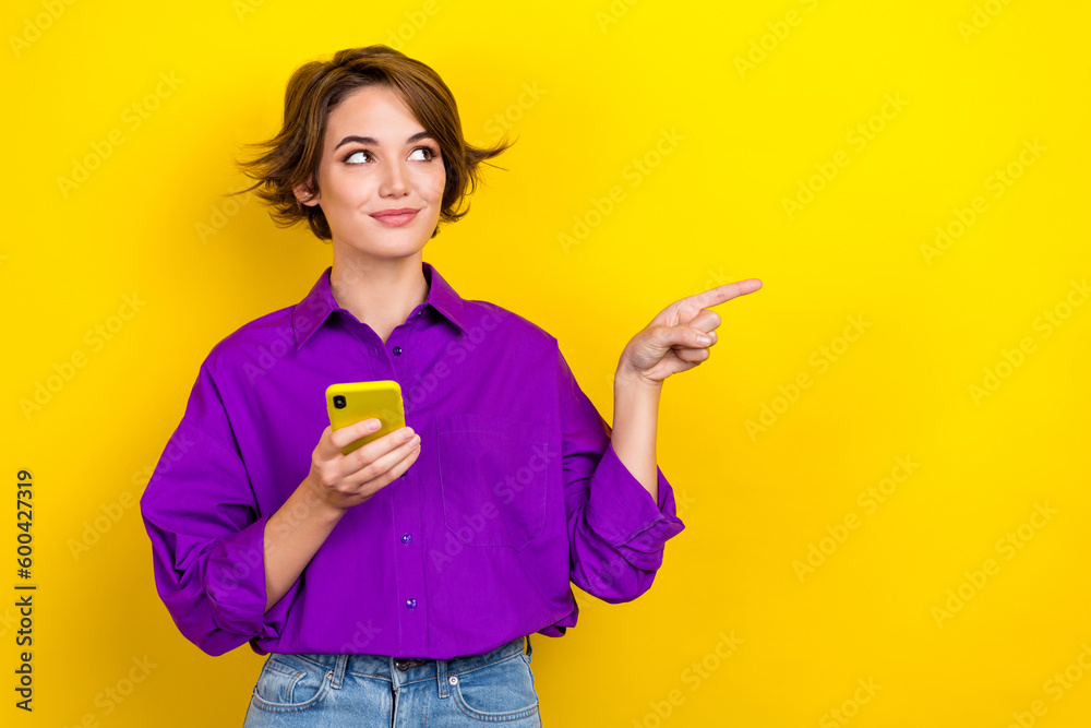Photo of charming person hold smart phone look direct finger empty space wear violet isolated on yellow color background - obrazy, fototapety, plakaty 