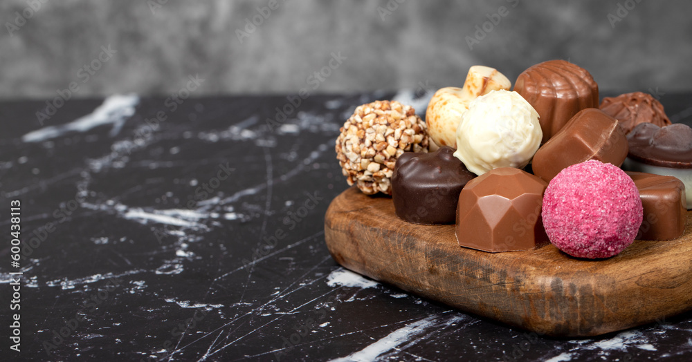 Praline Chocolate. Assorted truffles or praline chocolates on wood serving board. Copy space. Empty space for text