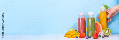  Green, orange and red smoothie in portion bottles, Mix of colourful healthy smoothie or juice drinks of different fruits: orange, grapefruit, lime, kivi, strawberry, with ingredients