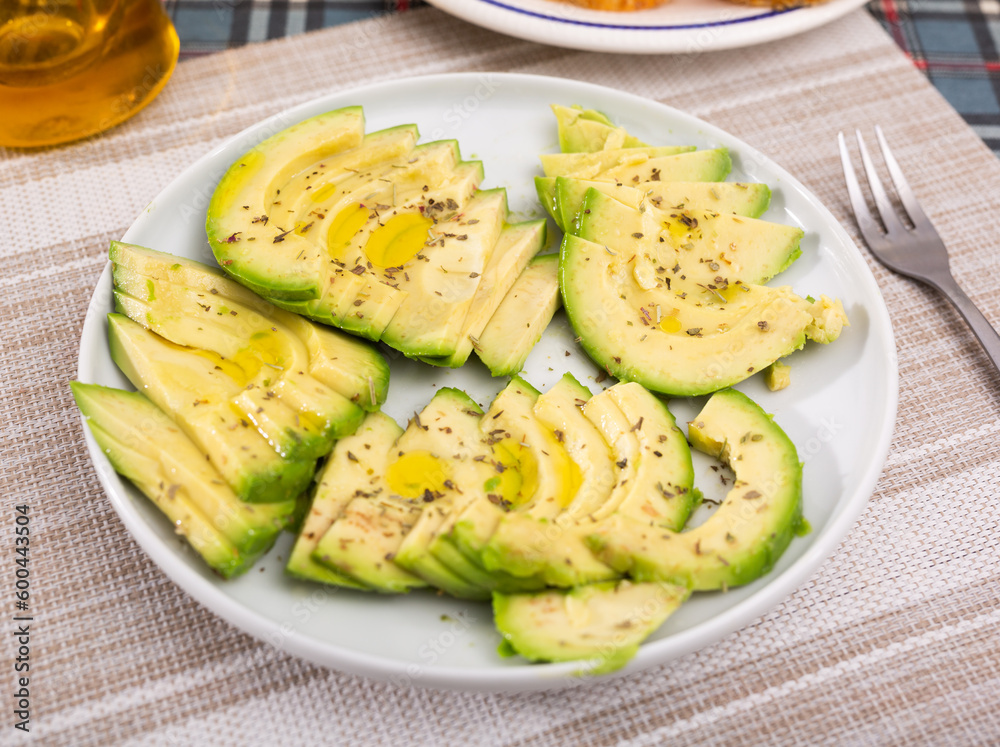ripe avocado pulp cut into pieces sprinkled with lemon juice on a plate