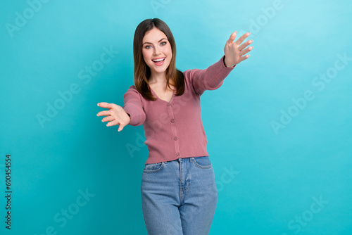 Photo of satisfied optimistic girl with straight hairdo dressed pink cardigan stretch hands to hug you isolated on blue color background