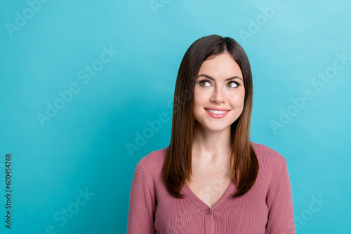 Photo of optimistic good mood girl with straight hairdo dressed pink cardigan look at offer empty space isolated on blue color background