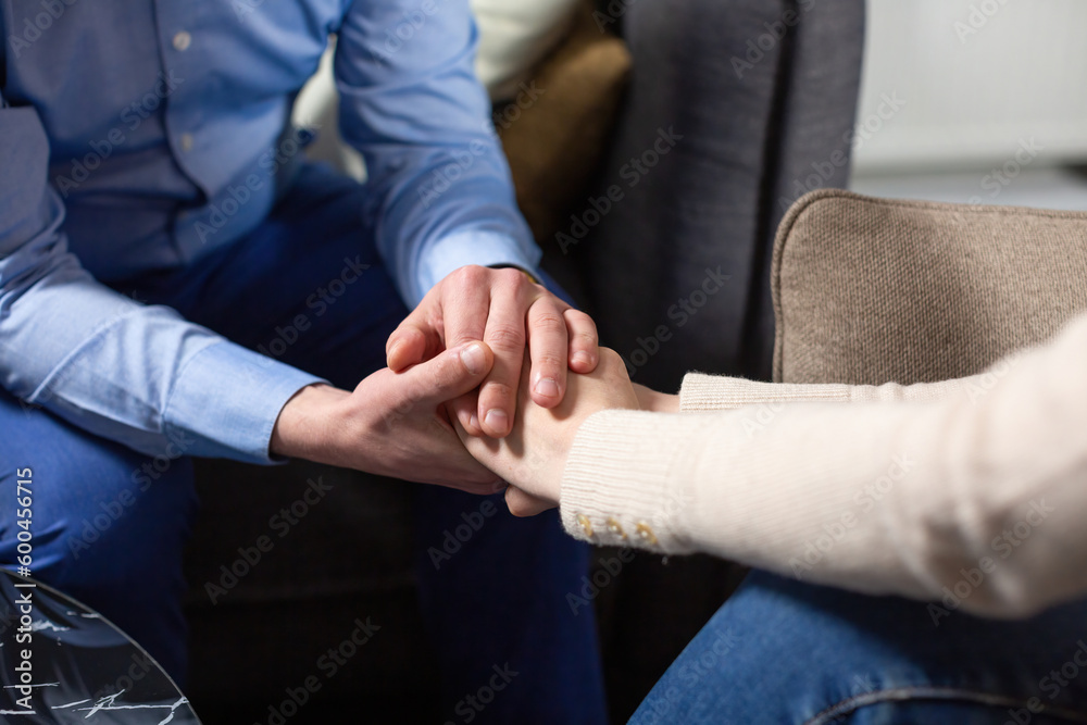 Man and woman hold hands after solving relationship conflict on therapy with psychologist. Effective psychological assistance for couple