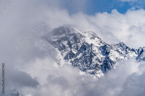 Mountain peak in clouds. Top of snowy rock in Georgia.