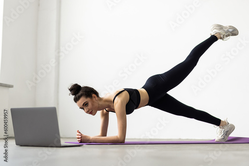 Young woman exercising at home  stretching legs in living room