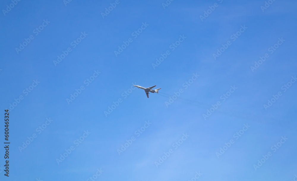 The plane flies high in the blue sky with small clouds The plane flies high in the blue sky with small clouds