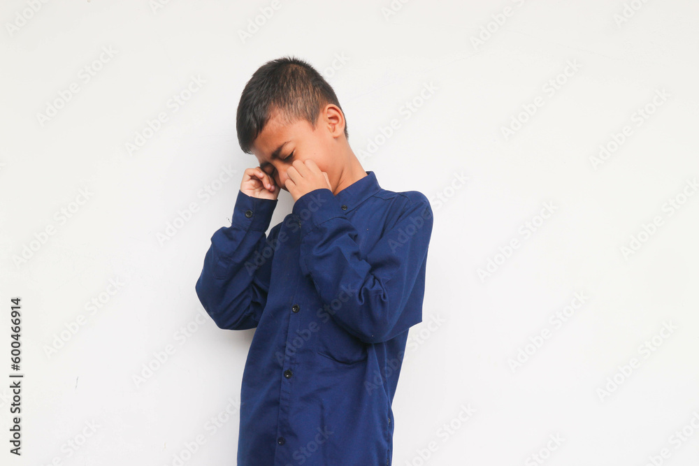 Sad boy wearing blue shirt isolated on white background Sad boy wearing blue shirt isolated on white background