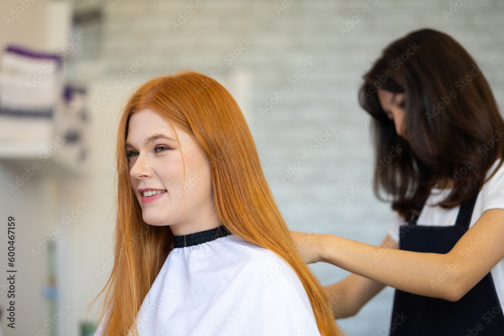 Professional Hairdresser trimming red hair with scissors. Caucasian red hair woman Professional Hairdresser trimming red hair with scissors. Caucasian red hair woman
