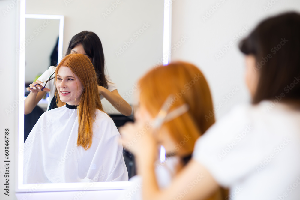 Professional Hairdresser trimming red hair with scissors. Caucasian red hair woman Professional Hairdresser trimming red hair with scissors. Caucasian red hair woman
