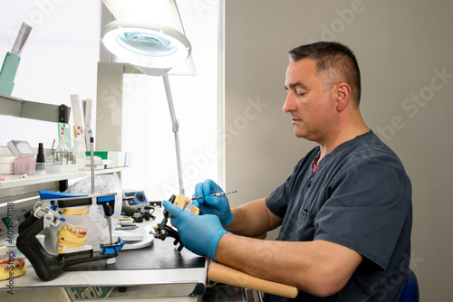 Dental technician working with tooth denture