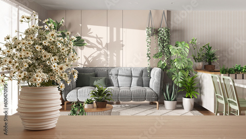 Wooden table top or shelf with pottery vase with daisies, wild flowers, over kitchen and living room in urban jungle style, houseplants, interior design concept