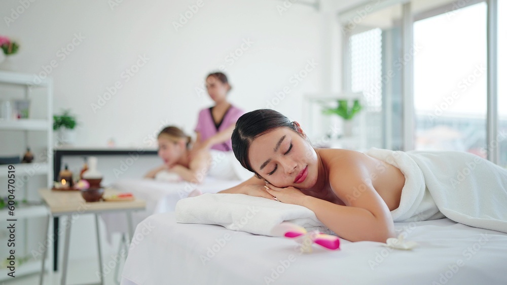 Relaxed woman in white towel lying on massage bed closed eyes waitting for massage therapy in the spa salon. Spa treatment concept