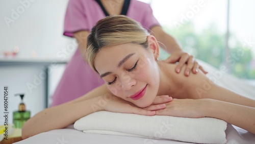 Close up face of relaxed young Asian woman lying on spa bed closed eyes and relaxed. Spa treatment, body relaxation concept