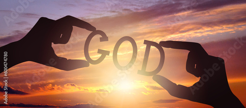 фотографія God - human hands holding black silhouette word