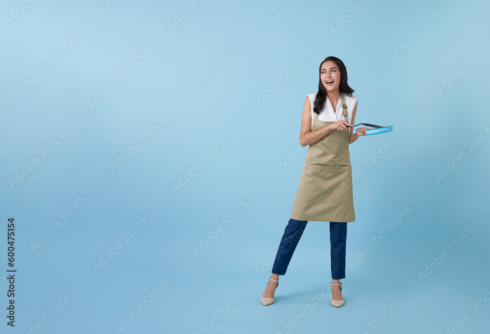 Entrepreneur Asian professional chief ready to cook, Chef holding spatula and frying pan isolated copy space on blue background. Entrepreneur Asian professional chief ready to cook, Chef holding spatula and frying pan isolated copy space on blue background.