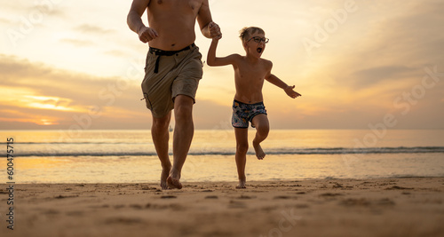 Father and son running on the beach 