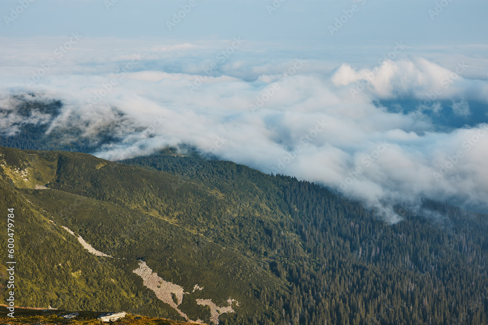 Mountain landscape. Scenic view of mountain peaks, slopes, hills and valleys covered with foggy slopes and valleys. Panoramic view