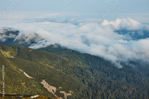 Fototapeta Naklejka Na Ścianę i Meble -  Mountain landscape. Scenic view of mountain peaks, slopes, hills and valleys covered with foggy slopes and valleys. Panoramic view