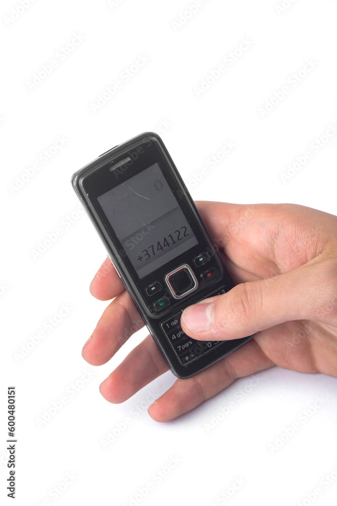 Old push-button cell phone in hand isolated on white background, clipping path included. Old push-button cell phone in hand isolated on white background, clipping path included.