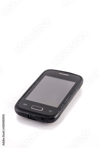 Old black mobile phone isolated on white background. Focus on the screen.