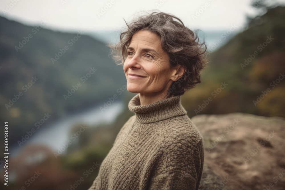 Portrait of a middle-aged woman in a sweater on the background of the river. Portrait of a middle-aged woman in a sweater on the background of the river.