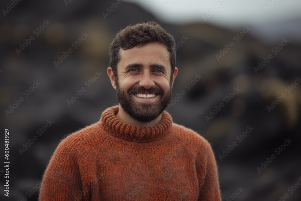 Portrait of smiling man in sweater standing on lava rocks in Iceland Portrait of smiling man in sweater standing on lava rocks in Iceland