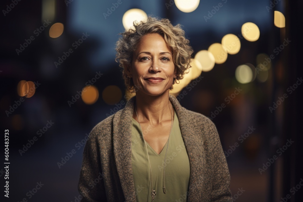 Portrait of beautiful middle-aged woman with curly hair on city street at night Portrait of beautiful middle-aged woman with curly hair on city street at night